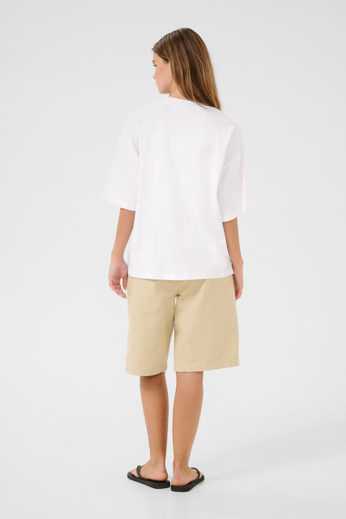 Person wearing a white tee and taupe shorts.
