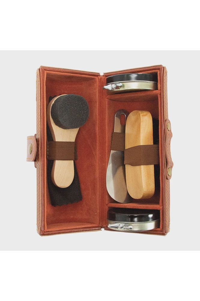 Annabel Trends Gentlemen's Shoe Shine Kit contained in a Vegan Leather Case.  Case sitting open shoeing the 5 pieces included a shoe horn, sponge brush, buffing brush and shoe polish .