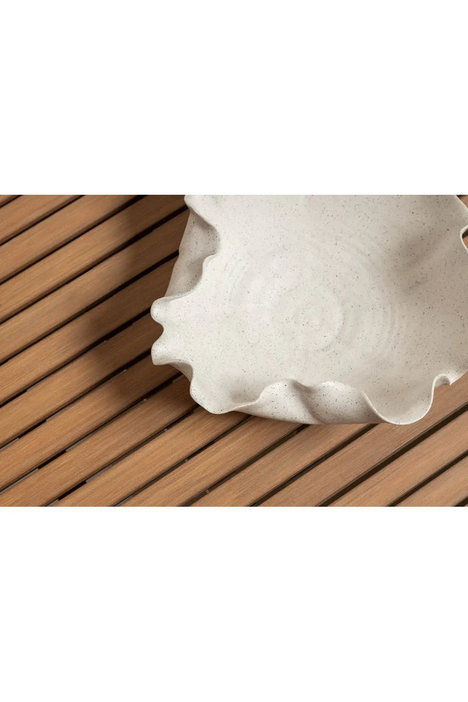 Ned Collection Close-up of handmade white ceramic Bluff Bowl on a wooden surface.