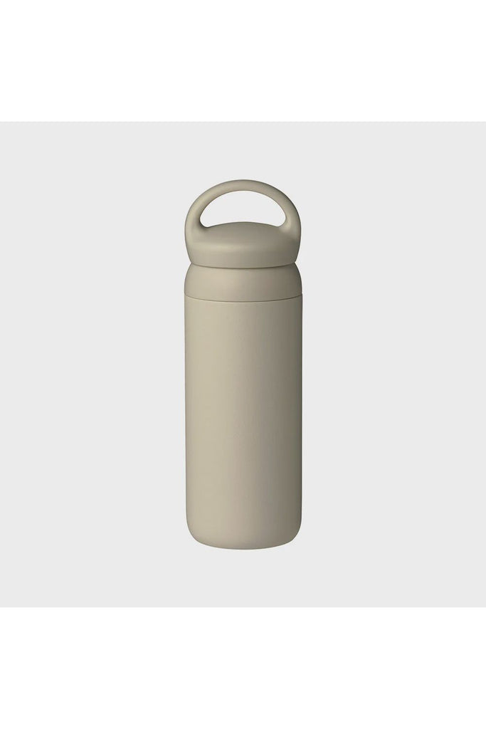 Kinto Day Off Tumbler in Sand Beige. Beige water bottle with a handle on a light grey background.