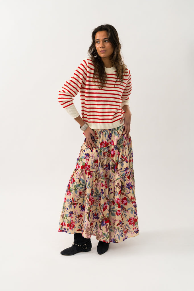 Woman wearing a striped sweater and floral skirt on a white background. Lollys Laundry Sunset Maxi Skirt in floral print.