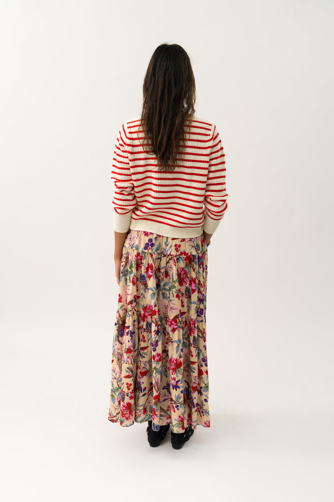 Woman wearing a striped sweater and floral skirt on a white background. Lollys Laundry Sunset Maxi Skirt in floral print.