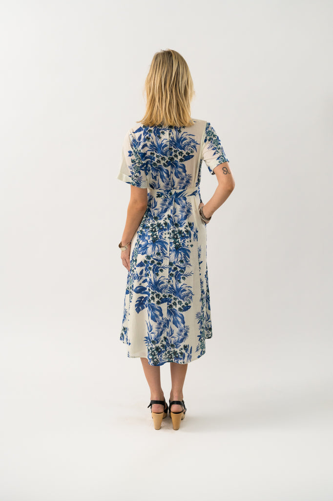 Woman wearing a blue floral dress on a white background