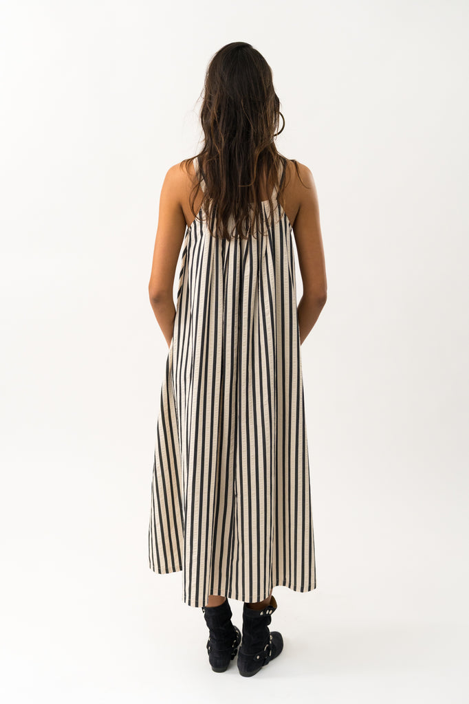 Woman wearing a black and white striped dress on a white background. Lollys Laundry Lungo Striped Sundress.