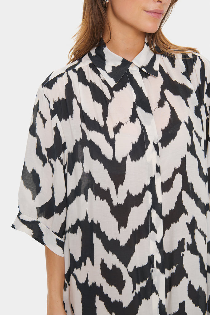 Black and white patterned dress worn by a person on a plain background. Saint Tropez Kelsie Shirt dress in black and white.