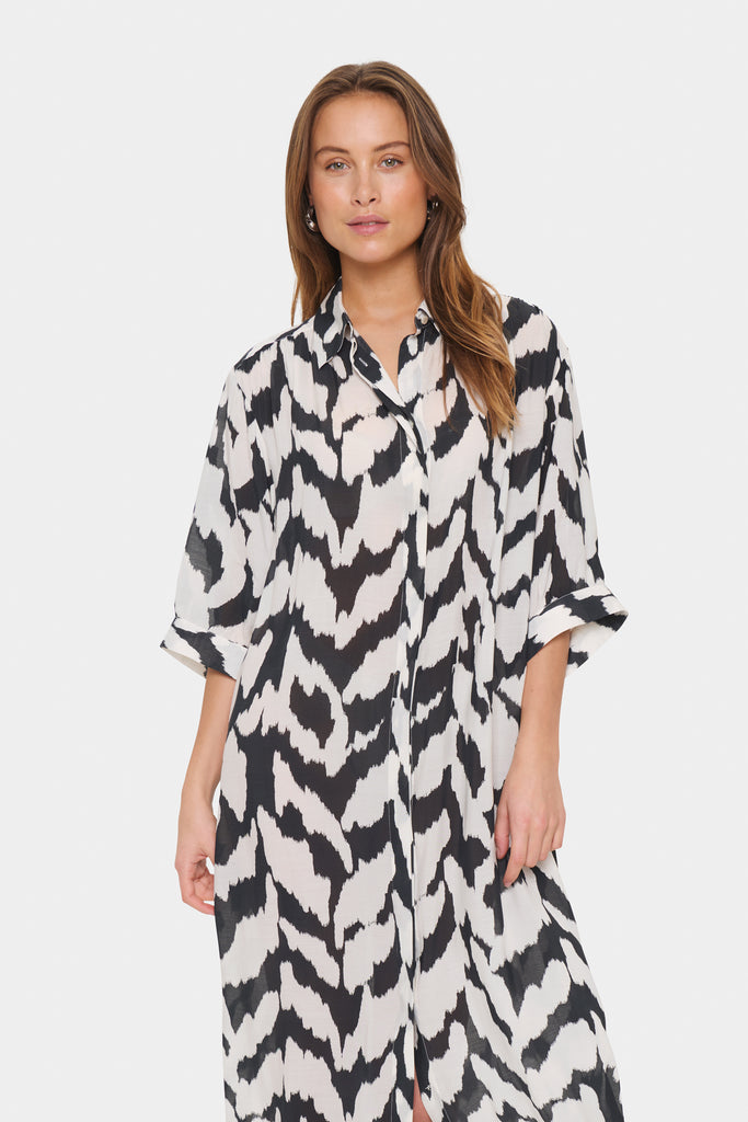 Black and white patterned dress worn by a person on a plain background. Saint Tropez Kelsie Shirt dress in black and white.