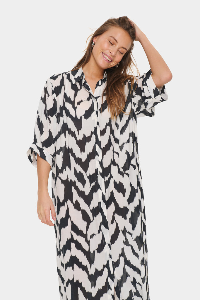 Black and white patterned dress worn by a person on a plain background. Saint Tropez Kelsie Shirt dress in black and white.