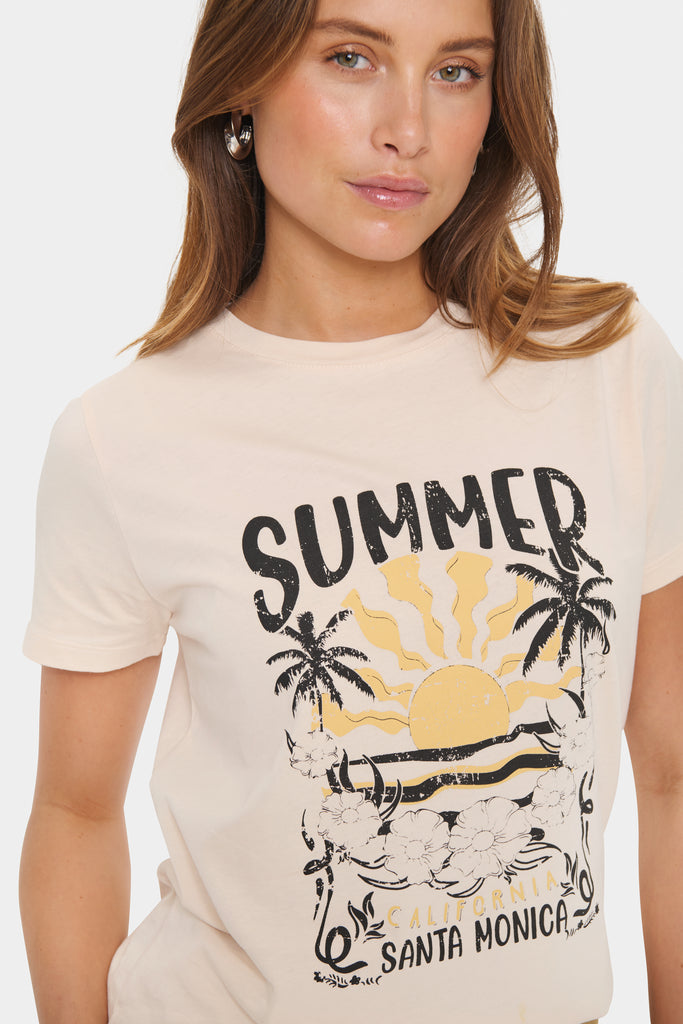 Woman wearing a 'Summer Santa Monica' t-shirt with a graphic design. Saint Tropez Kuvi Tee