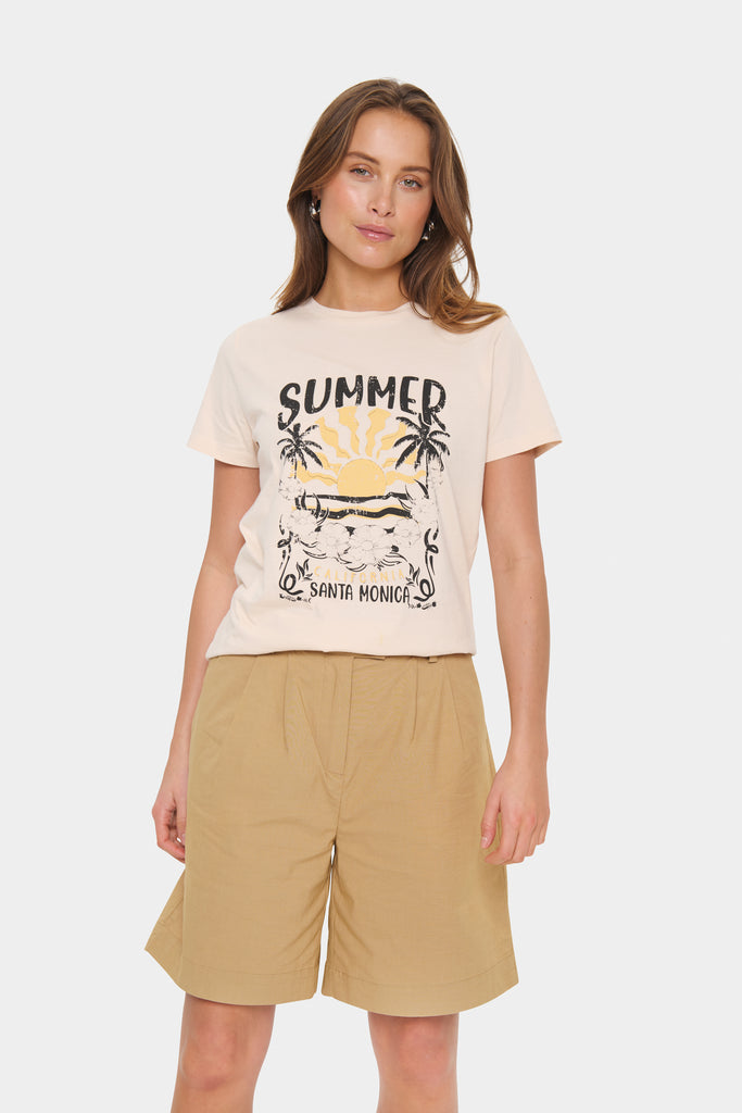 Woman wearing a 'Summer Santa Monica' t-shirt with a graphic design. Saint Tropez Kuvi Tee