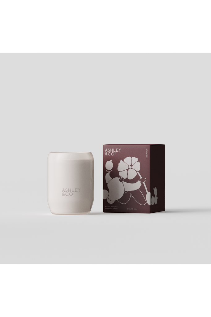 Clear Cut image of Ashley & Co's Limited Edition Bonberry Candle.  Image showing white glass vessel holding the natural wax candle and the burgundy packaging box featuring a bespoke illustration by Copenhagen-based illustrator Morten Kantsø