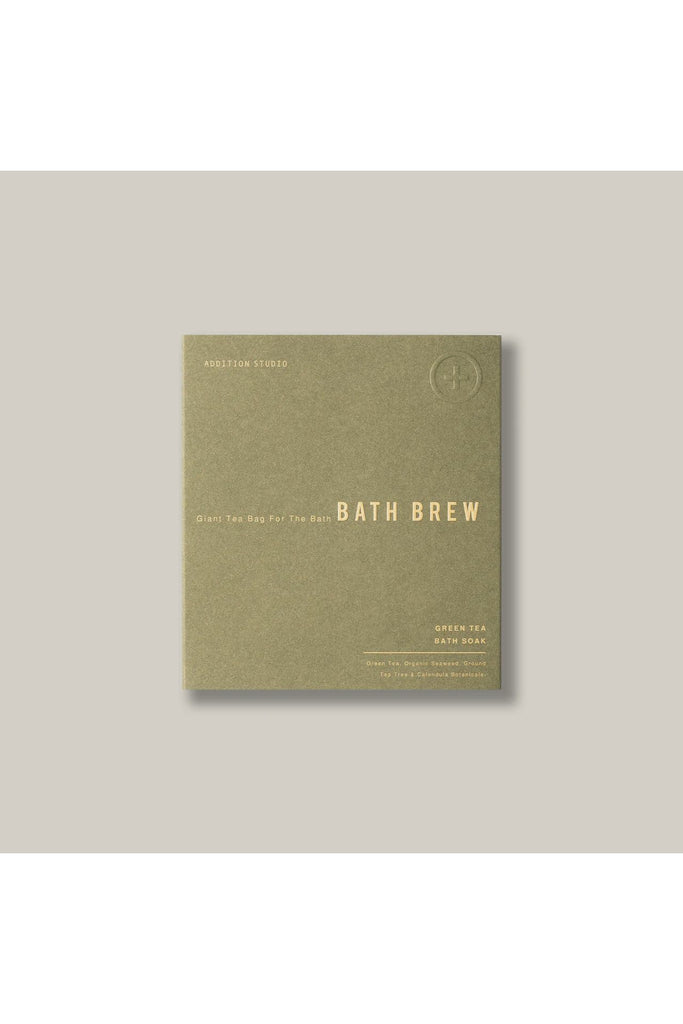 Addition Studio Giant Tea Bag for the Bath Brew. Green package of Bath Brew with gold text on a grey background.