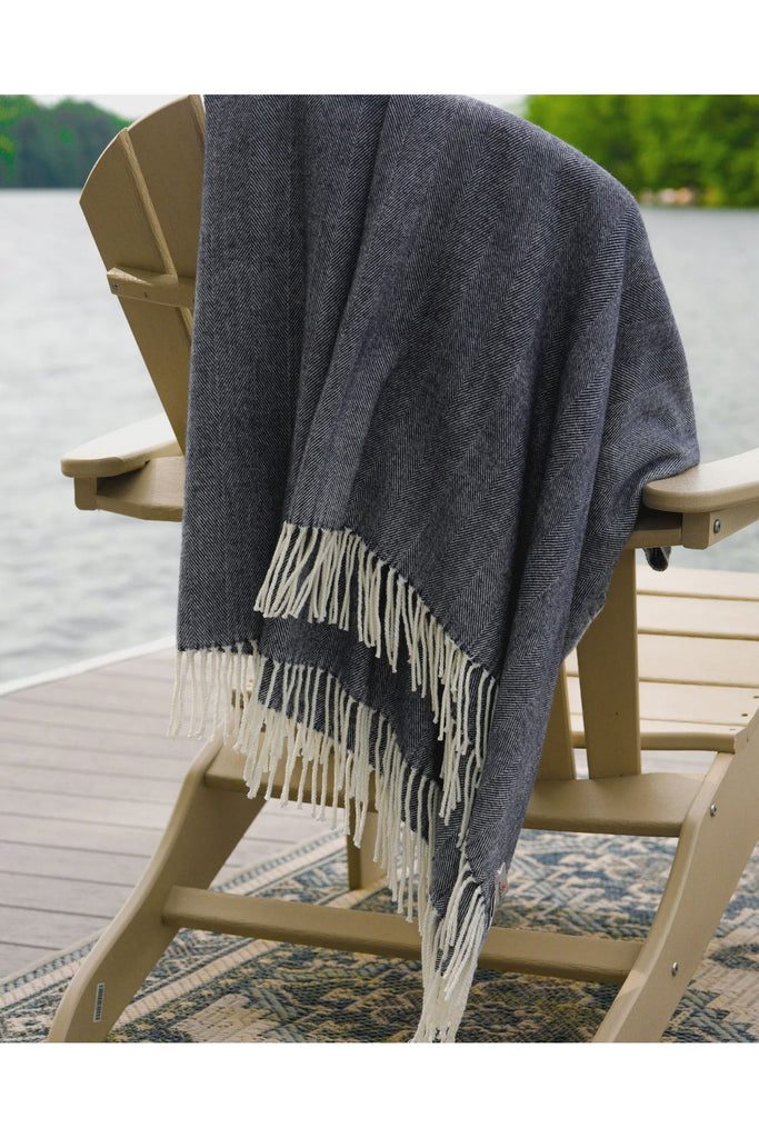 Alashan-Cotton-Acrylic-Adirondack-Herringbone-Woven-Throw-in-Onyx-Black--Throw-shown-draped-over-the-back-of-a-Cape-Code-Chair-outside