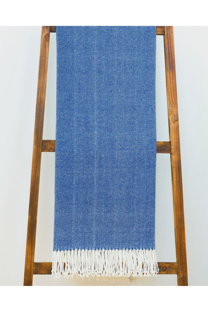 Alashan-Cotton-Acrylic-Adriondack-Herringbone-Woven-Throw-in-Ocean-Blue---Throw-shown-hanging-over-a-wooden-ladder