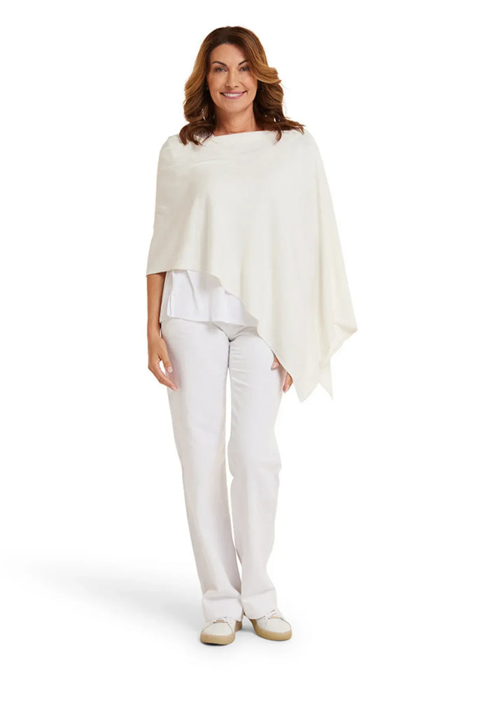 Woman wearing a white shawl over a white top and pants on a white background. Alashan Cotton Cashmere Topper in Off White.
