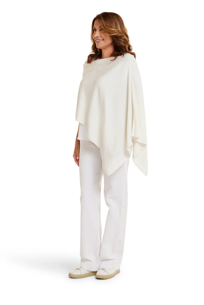 Woman wearing a white shawl over a white top and pants on a white background. Alashan Cotton Cashmere Topper in Off White.