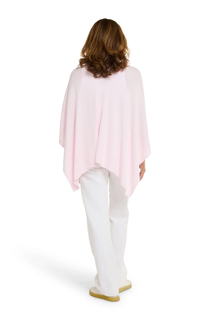Woman wearing a light pink top and white pants on a white background. Alashan Cotton Cashmere Topper in Pink Sugar.