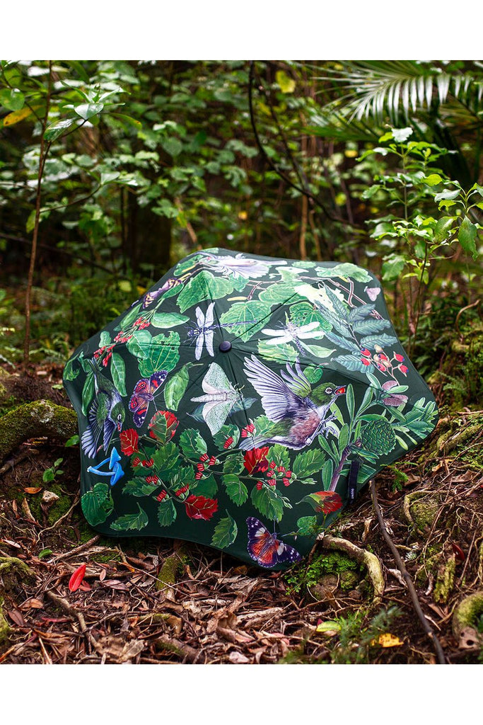 Blunt x Forest & Bird Metro Umbrella featuring design by Erin Forsyth. Image shows the exterior of the canopy of the umbrella whilst placed on the forest floor surrounded by NZ native foilage..