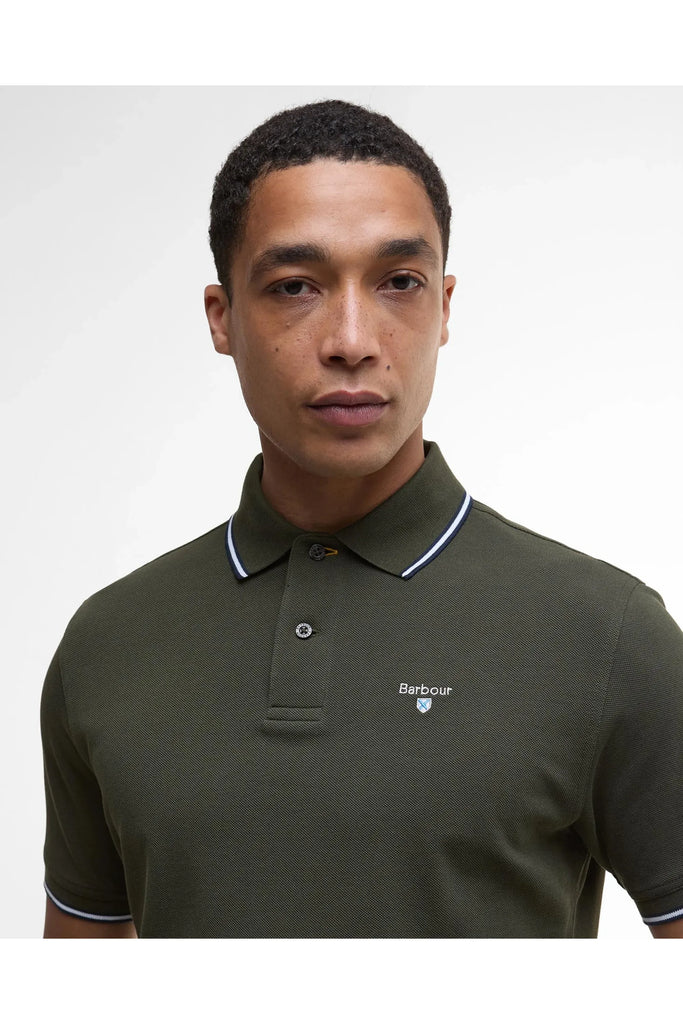 Man wearing the Barbour Fielding Tailored Polo Shirt in Olive against a grey background