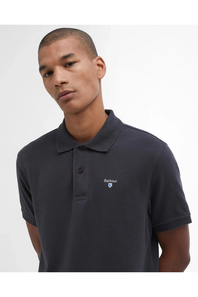 Man wearing a dark polo shirt on a white background. Barbour Original Sports tailored Polo in Navy.