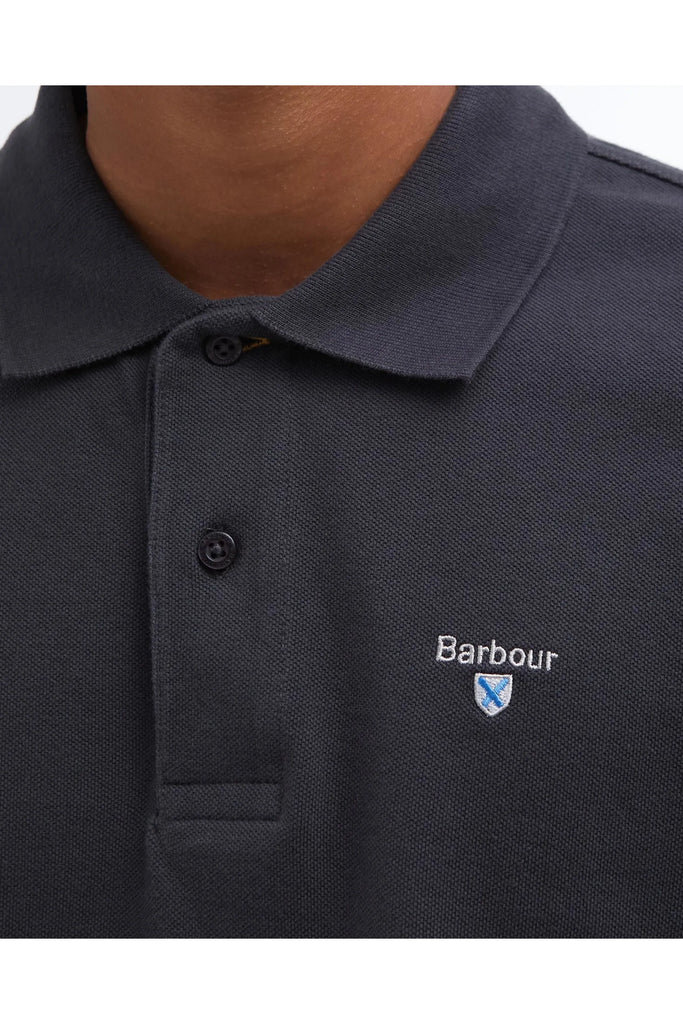 Close up of a man wearing a dark polo shirt on a white background. Barbour Original Sports Tailored Polo in Navy.
