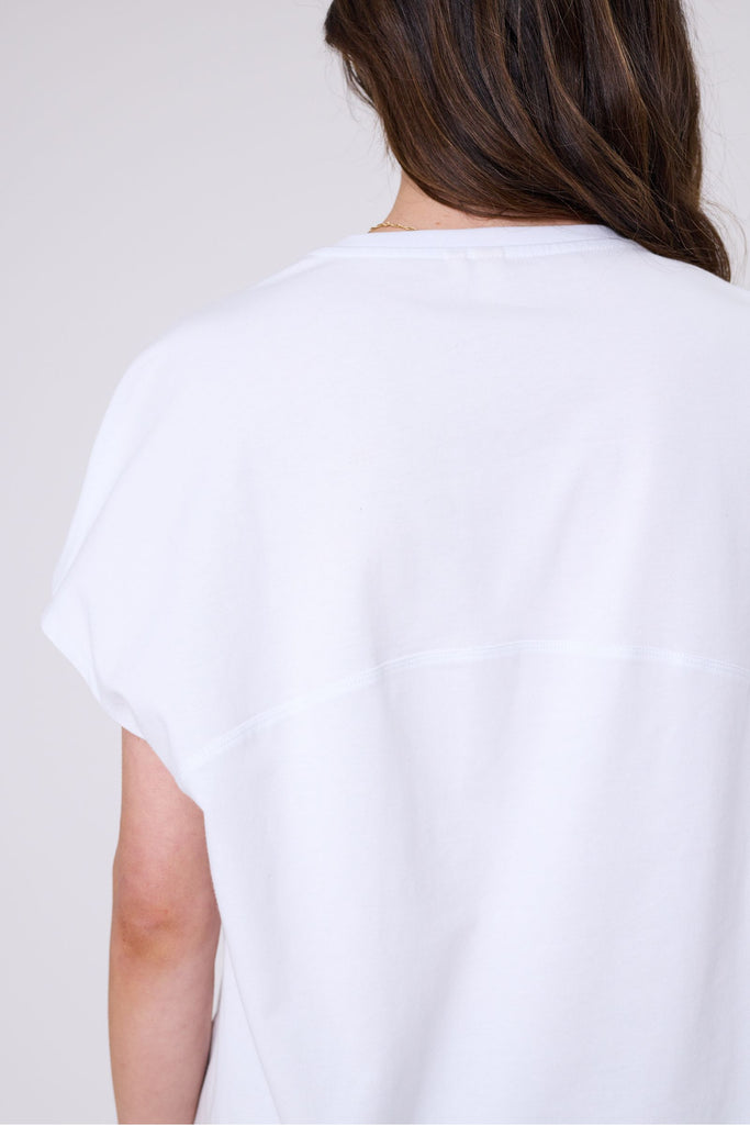 Woman wearing a white t-shirt on a white background. Marlow white Barrel Tee.