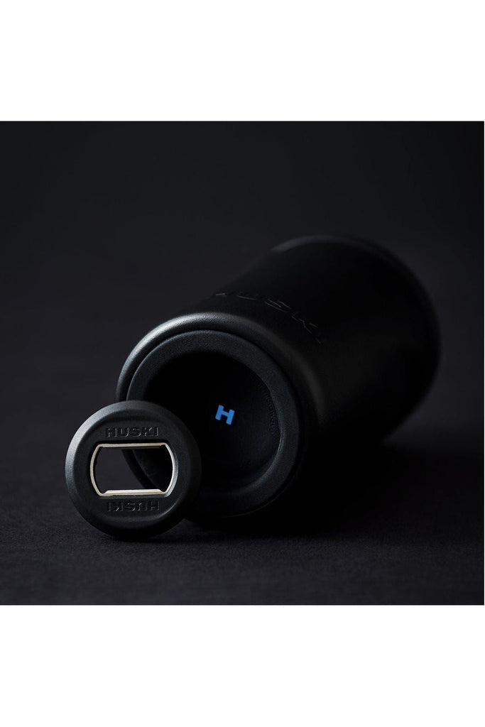 Black bottle opener with 'HUSKI' branding on a dark background