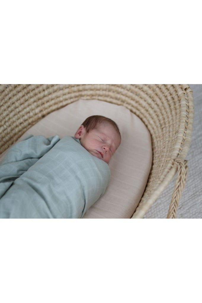 Burrow & Be Essentials Organic Muslin Baby Wrap in Sage Green.  Image shows Newborn wrapped in Muslin Wrap.