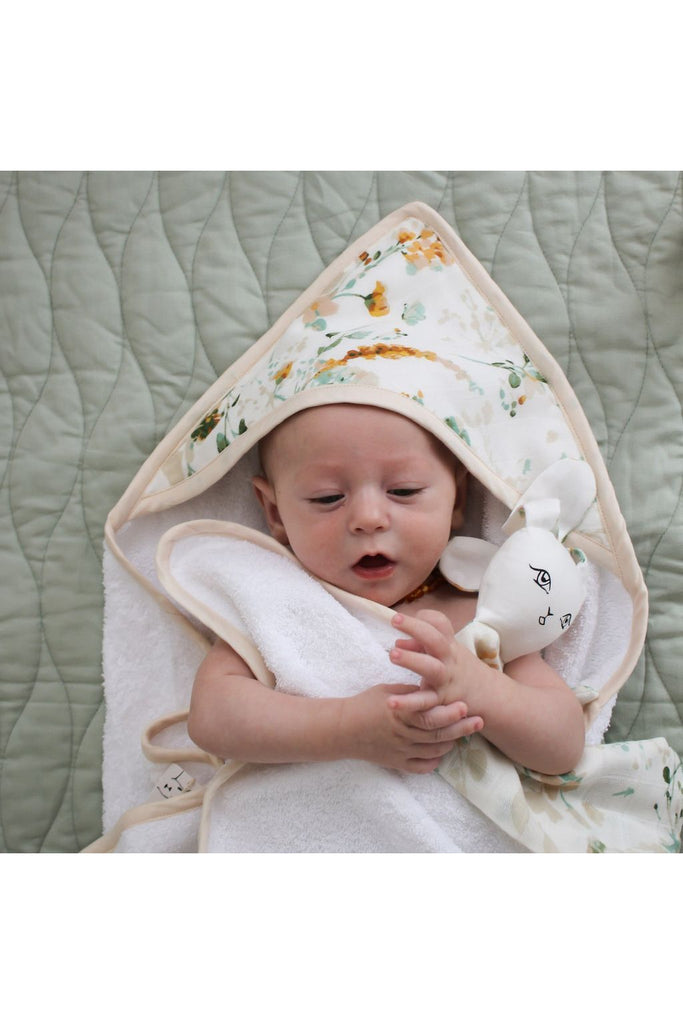 Burrow & Be Spring Melody Hooded Towel . Image shows baby wrapped in hooded towel with hood sitting covering the  top of the baby's head.