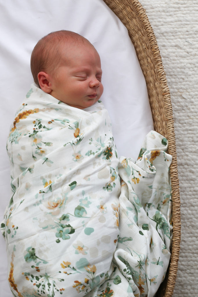 Burrow & Be Spring Melody Organic Muslin Baby Wrap. Image shows Baby wrapped up in the muslin wrap.