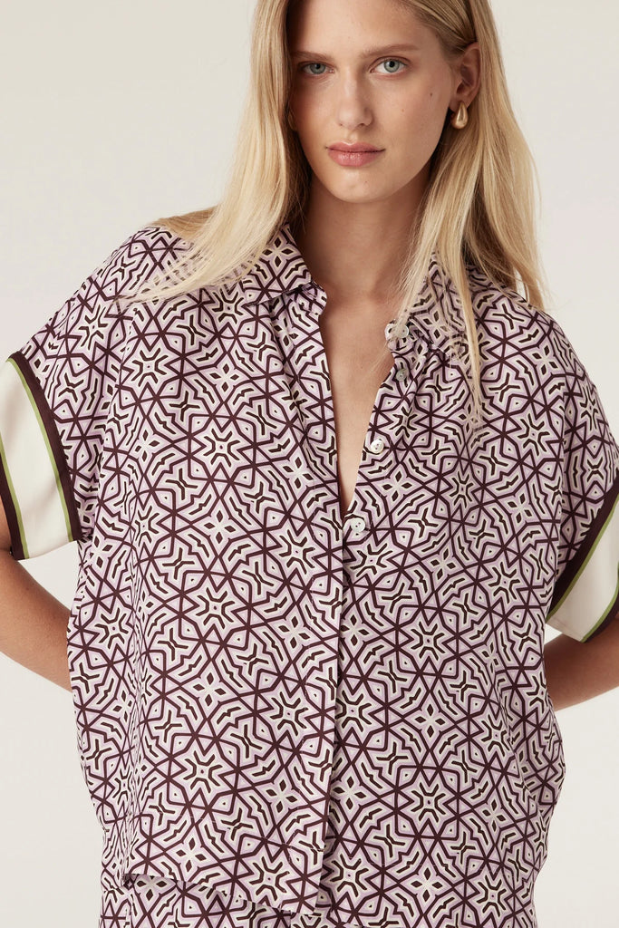 Woman wearing a patterned outfit with a plain background. Cable Melbourne Nova Blouse and matching Pant in Lattice Print.