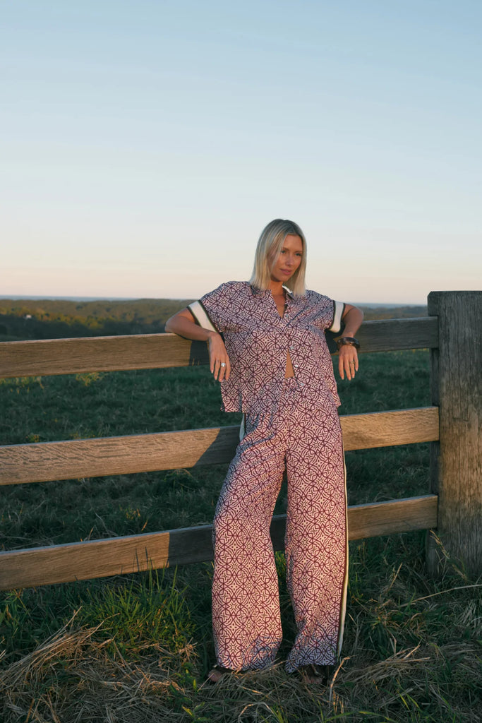 Woman wearing a patterned matching top and pant. Cable Melbourne Nova Blouse and Nova Pant in Lattice Print.
