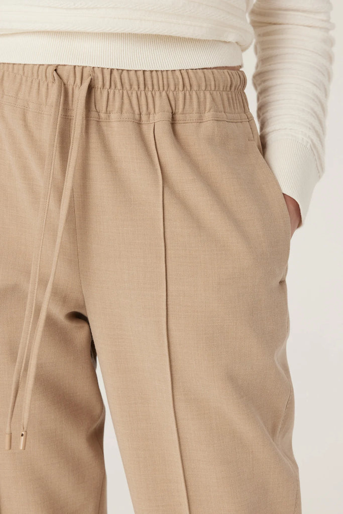 Person wearing beige pants with a white background. Cable Pierre Pant in Light Camel.