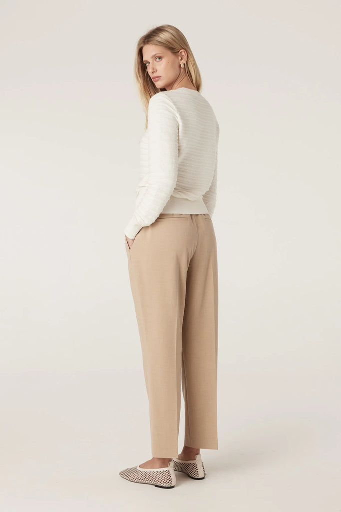 Person wearing beige pants with a white background. Cable Pierre Pant in Light Camel.