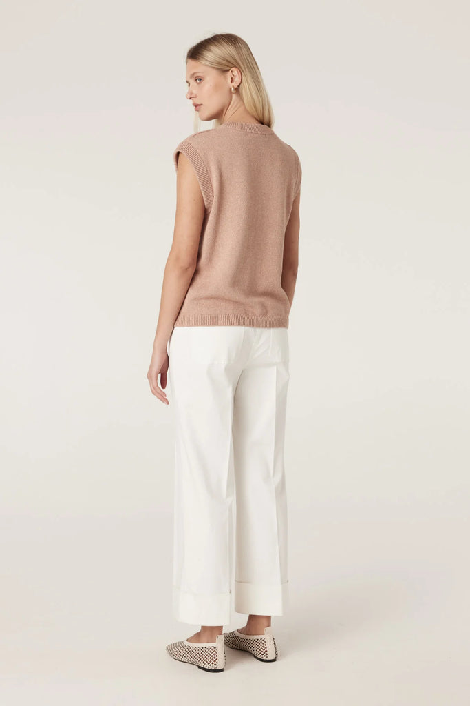 Woman wearing a beige sleeveless top and white pants on a plain background, Cable Porto Pant in white.