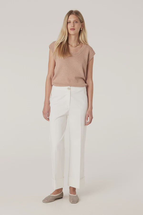 Woman wearing a beige sleeveless top and white pants on a plain background, Cable Porto Pant in white.
