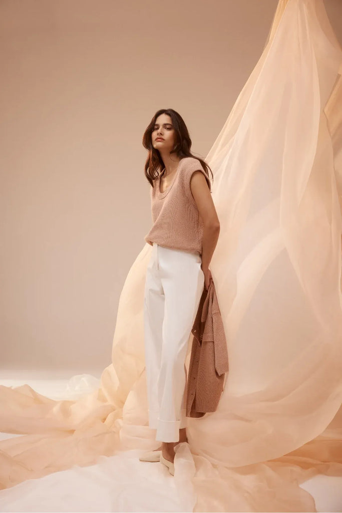 Woman wearing a beige sleeveless top and white pants.  Cable Porto Pant in white.