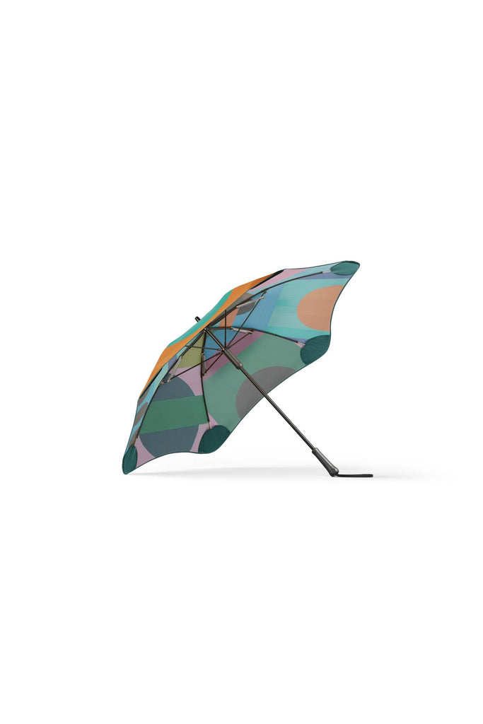 Limited edition collaboration between Blunt and Daimon Downey. A colourful, classic umbrella featuring a geometric pattern on a white background.