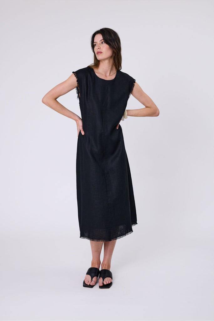Woman wearing a black dress on a white background. Marlow Costa Linen dress in Black.