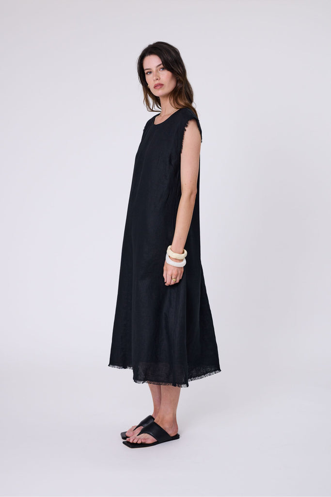 Woman wearing a black dress on a white background. Marlow Costa Linen dress in Black.