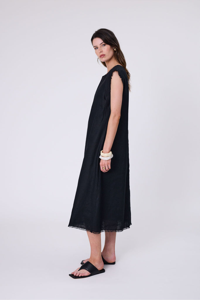 Woman wearing a black dress on a white background. Marlow Costa Linen dress in Black.