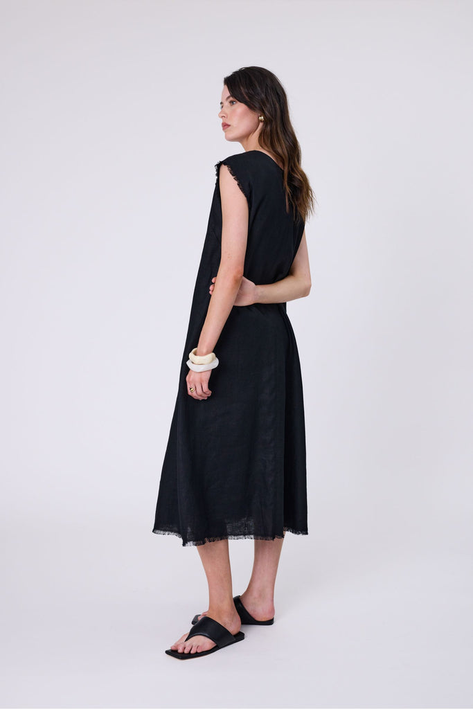 Woman wearing a black dress on a white background. Marlow Costa Linen dress in Black.