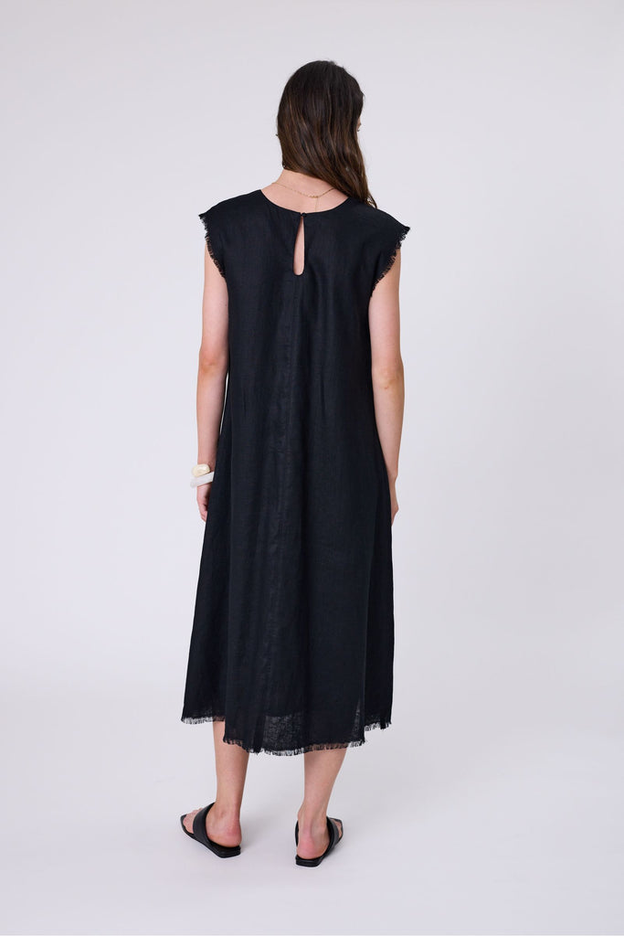 Woman wearing a black dress on a white background. Marlow Costa Linen dress in Black.