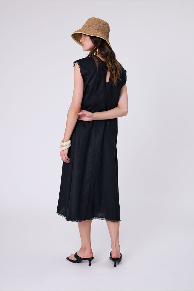 Woman wearing a black dress on a white background. Marlow Costa Linen dress in Black.