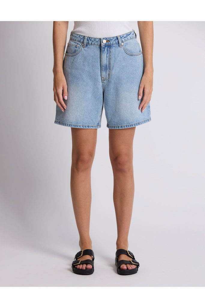Person wearing denim shorts on a plain background. Stella and Gemma Light Blue Denim Emily Shorts.