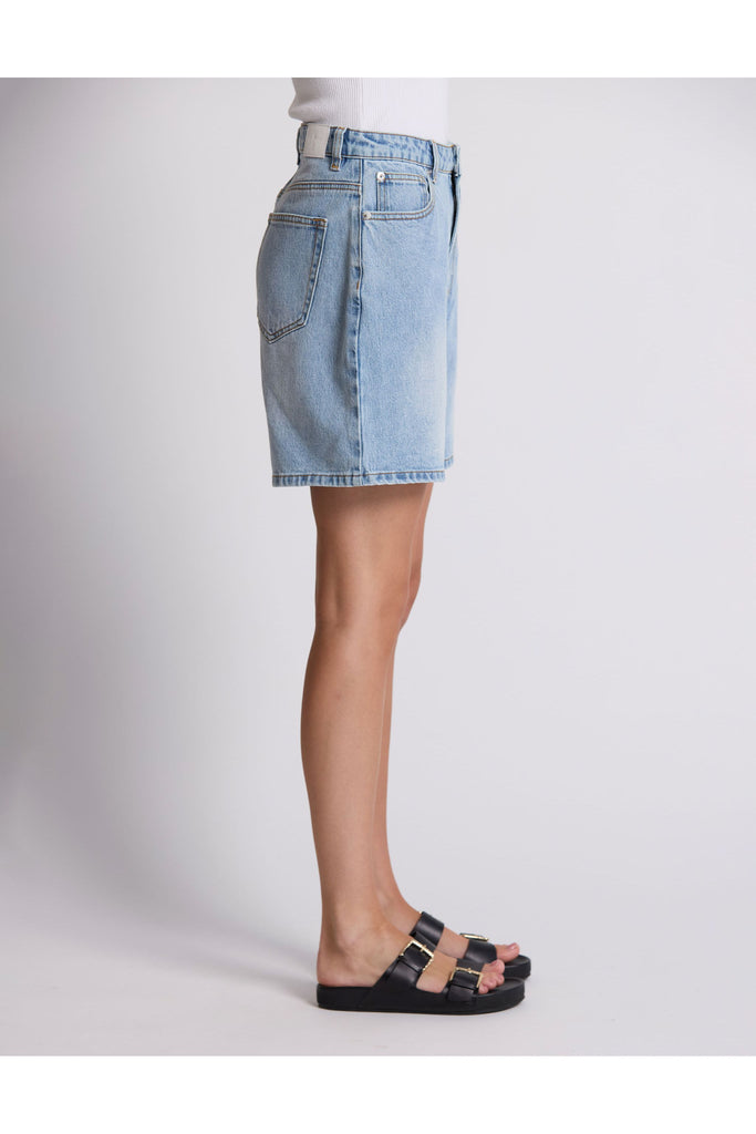 Person wearing denim shorts on a plain background. Stella and Gemma Light Blue Denim Emily Shorts.