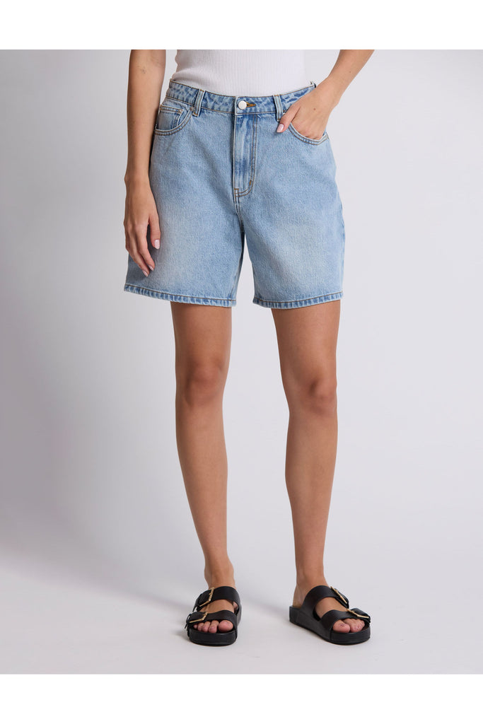 Person wearing denim shorts on a plain background. Stella and Gemma Light Blue Denim Emily Shorts.