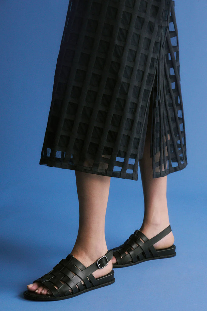 Woman wearing a dark blue checkered dress on a white background. Elk Grid Burnout Dress in Space Blue.