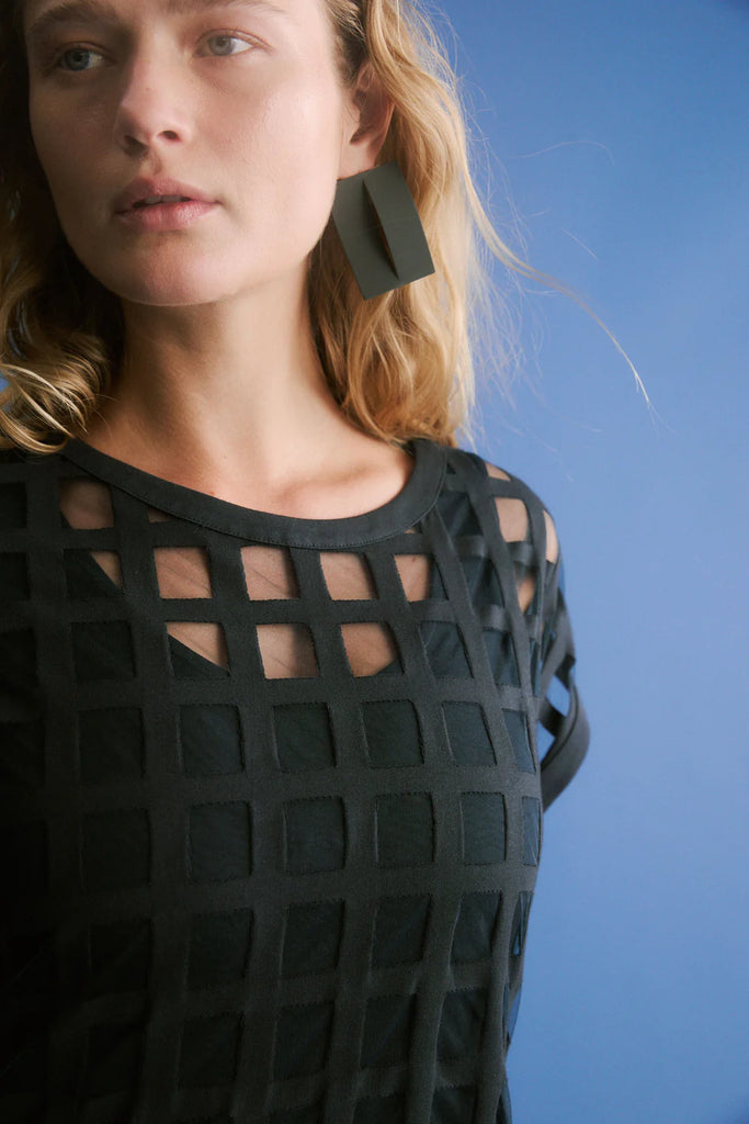Woman wearing a dark blue checkered dress on a white background. Elk Grid Burnout Dress in Space Blue.