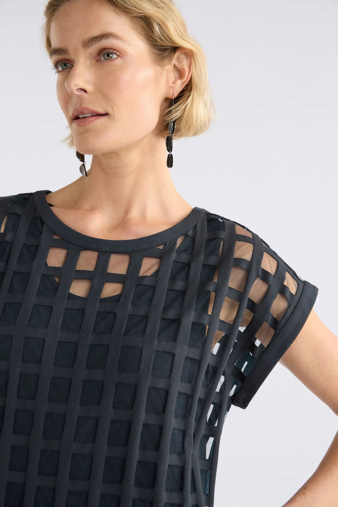 Woman wearing a dark blue checkered dress on a white background. Elk Grid Burnout Dress in Space Blue.