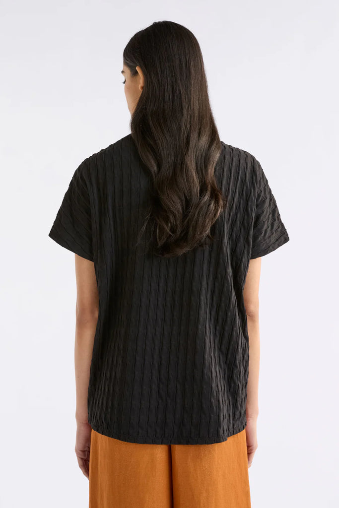 Woman wearing an Elk black textured top called the Orta T Shirt